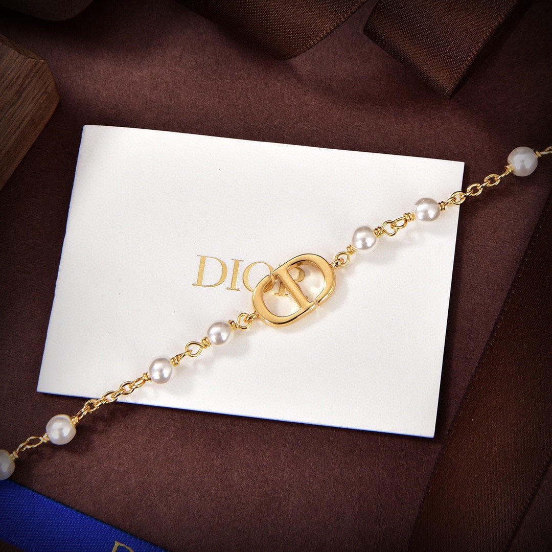 D logo and pearls bracket in gold