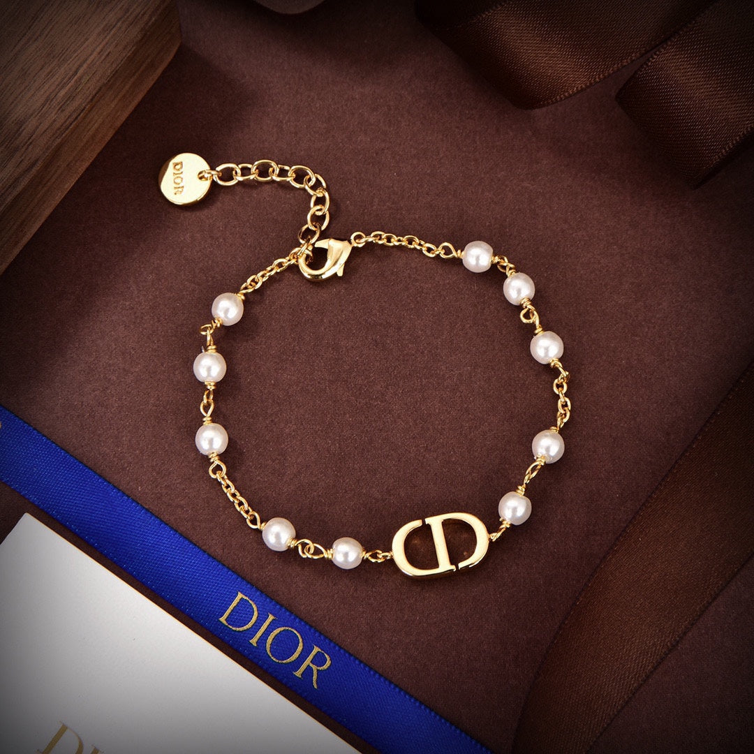 D logo and pearls bracket in gold