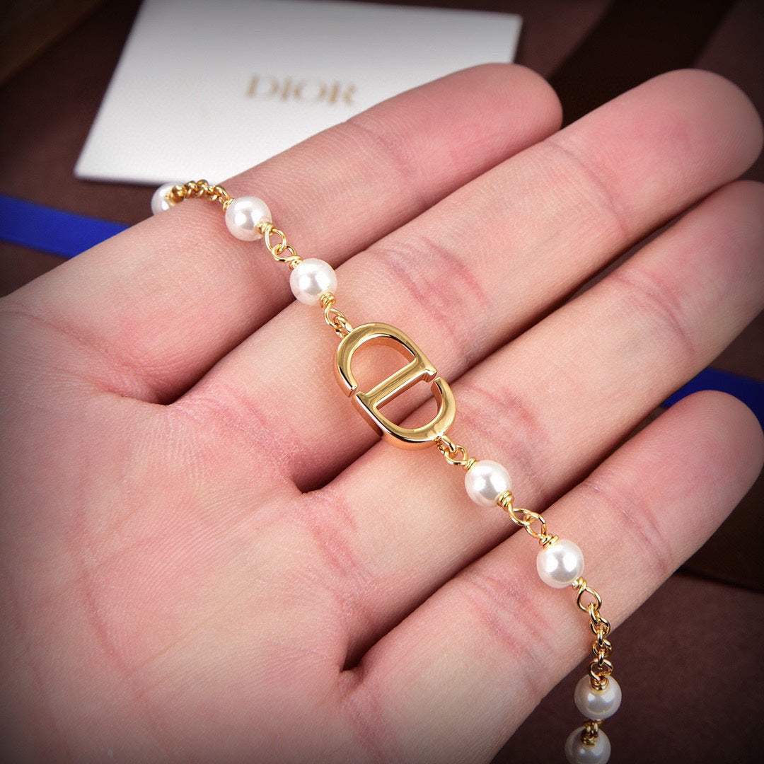 D logo and pearls bracket in gold